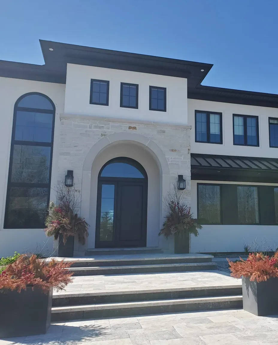 Custom residence finished by ITALSTUCCO with smooth stucco, limestone and an arched entrance