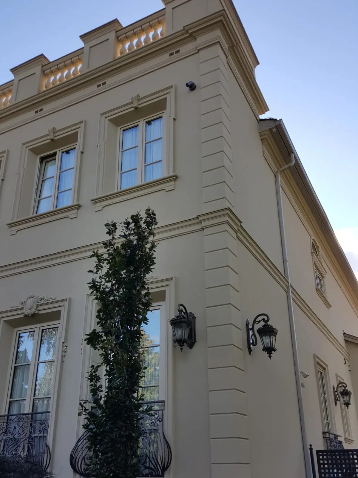 Corner of a cream stucco residence with layered horizontal banding
